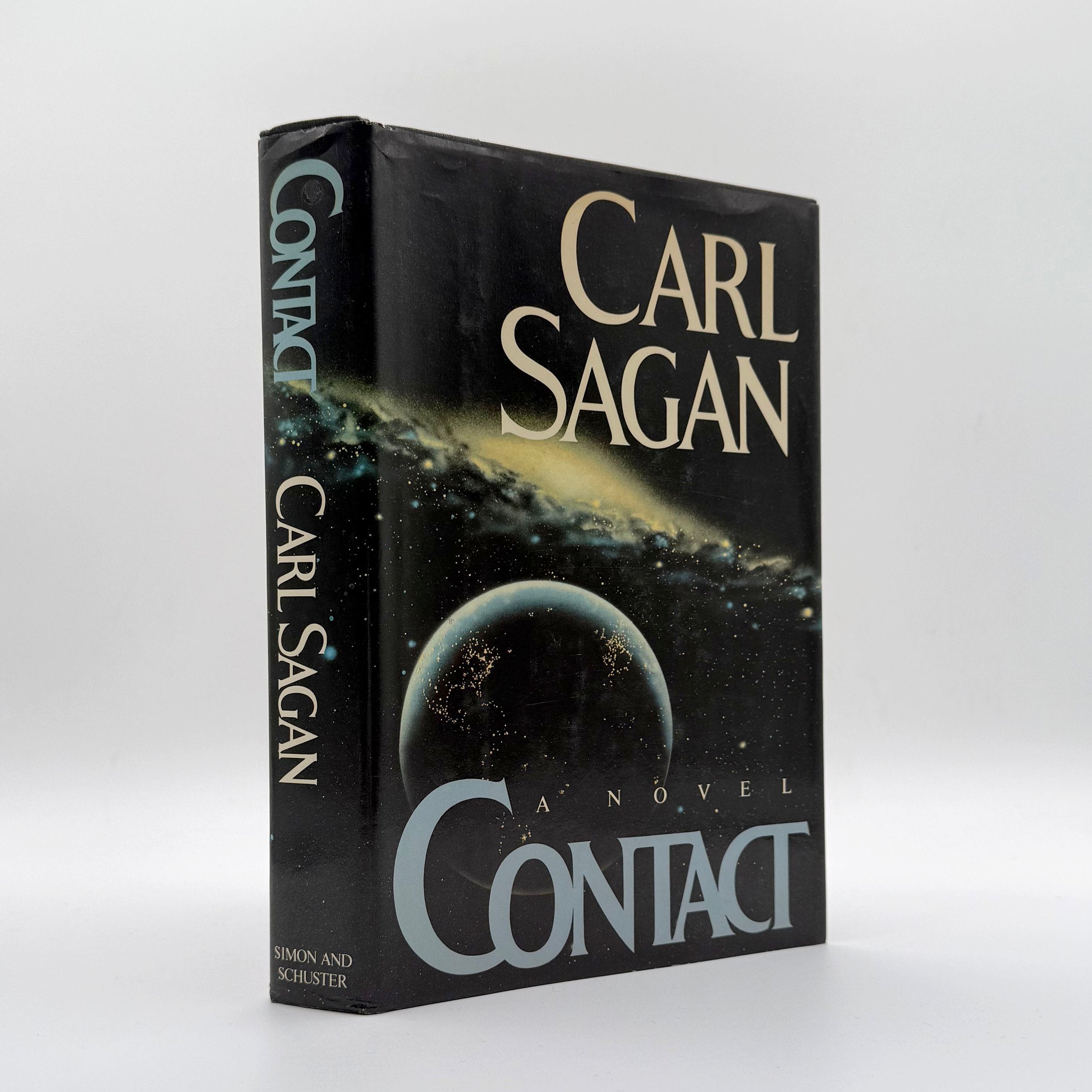 Book titled 'Contact' by Carl Sagan on a white background