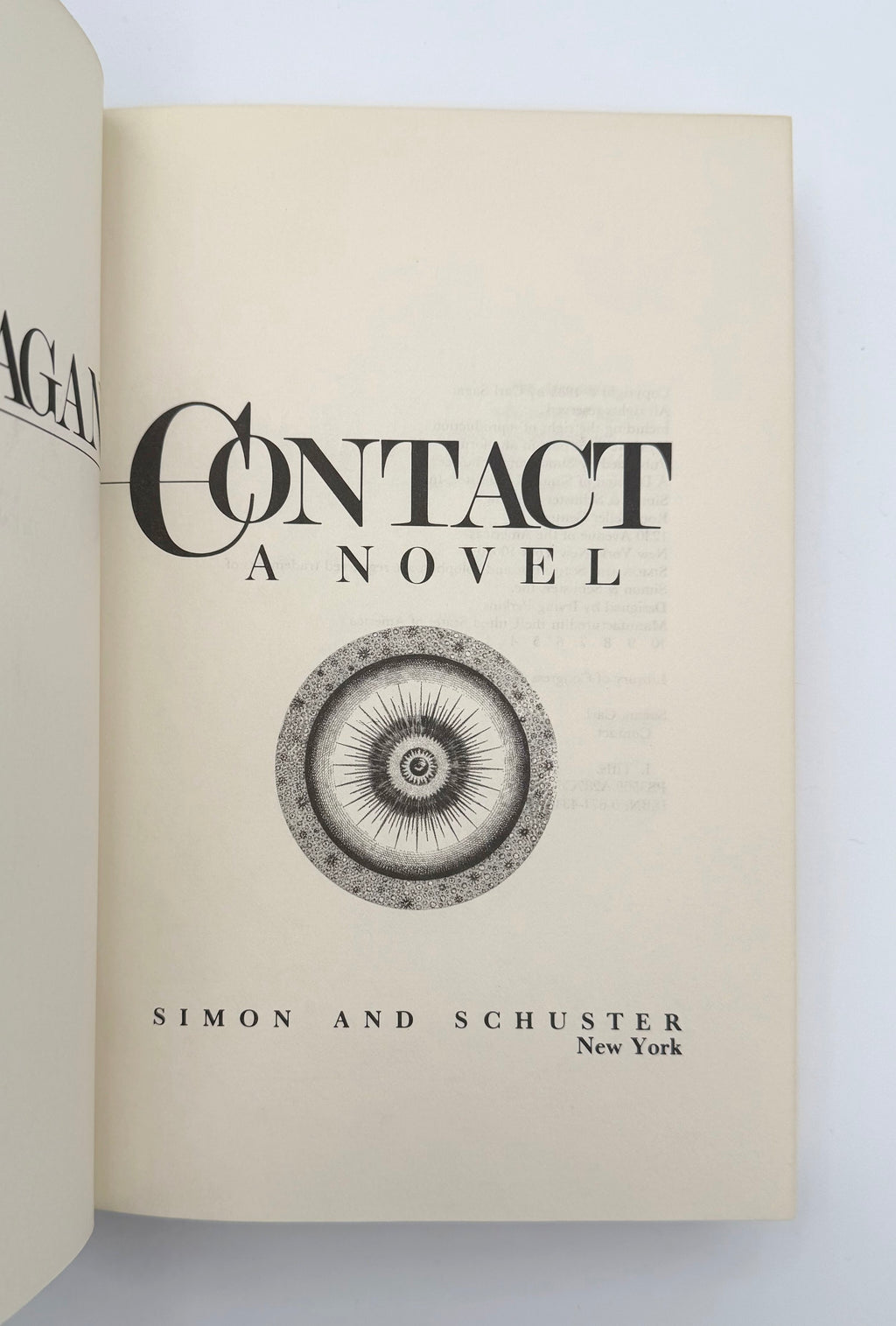 Open book showing the title 'Contact: A Novel' by Simon & Schuster on a light background