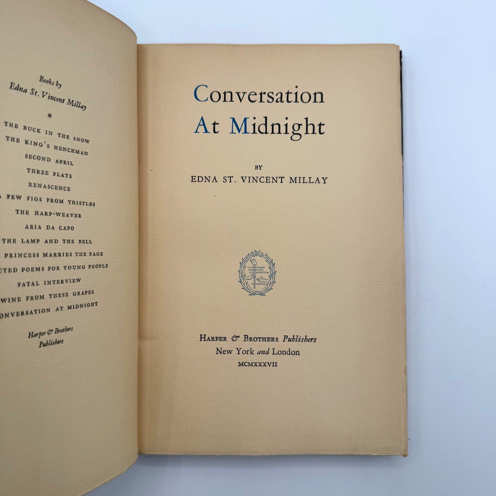 Open book with title page of 'Conversation At Midnight' by Edna St. Vincent Millay on a light blue background