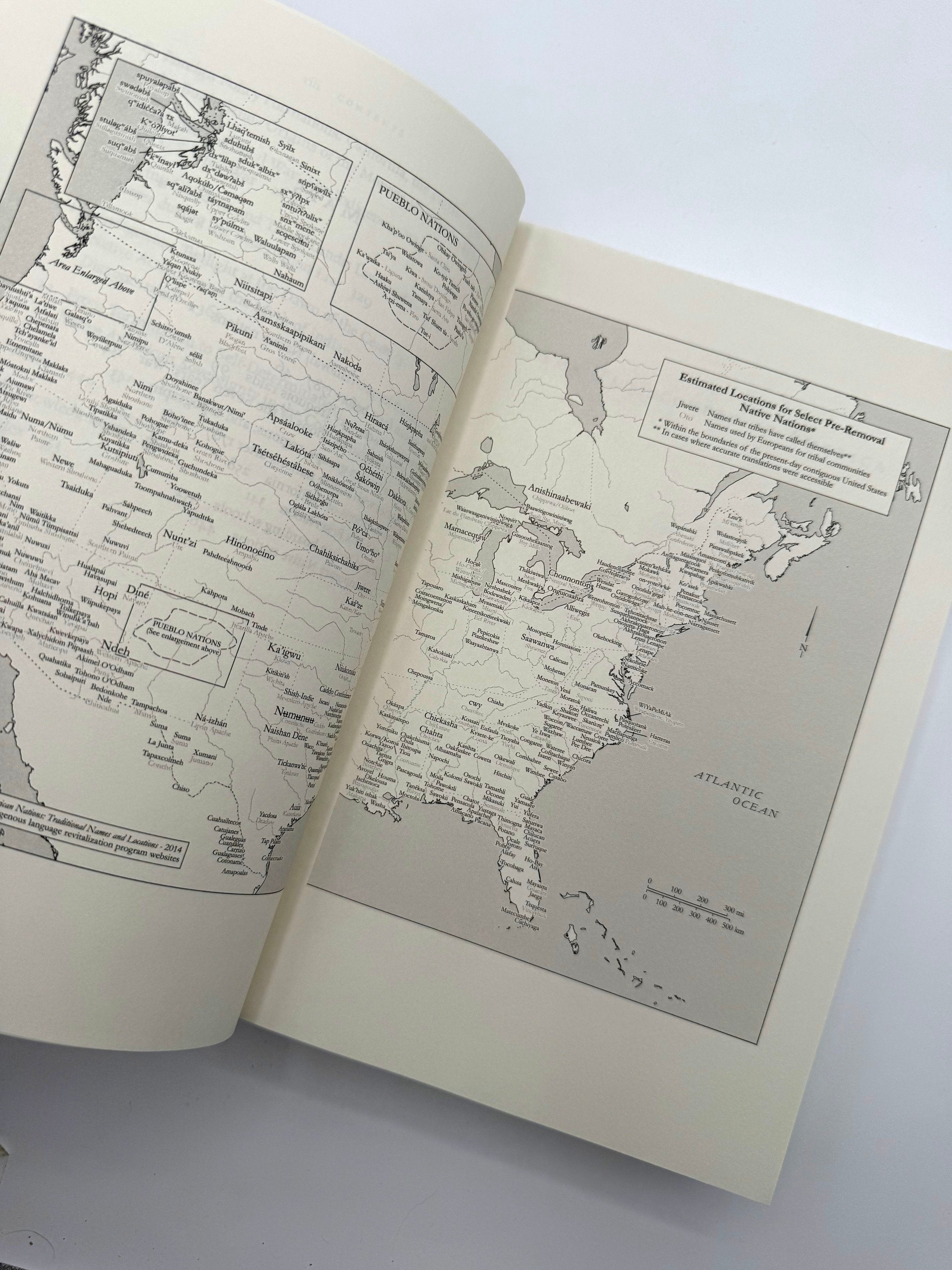 Open book with detailed maps on a white background