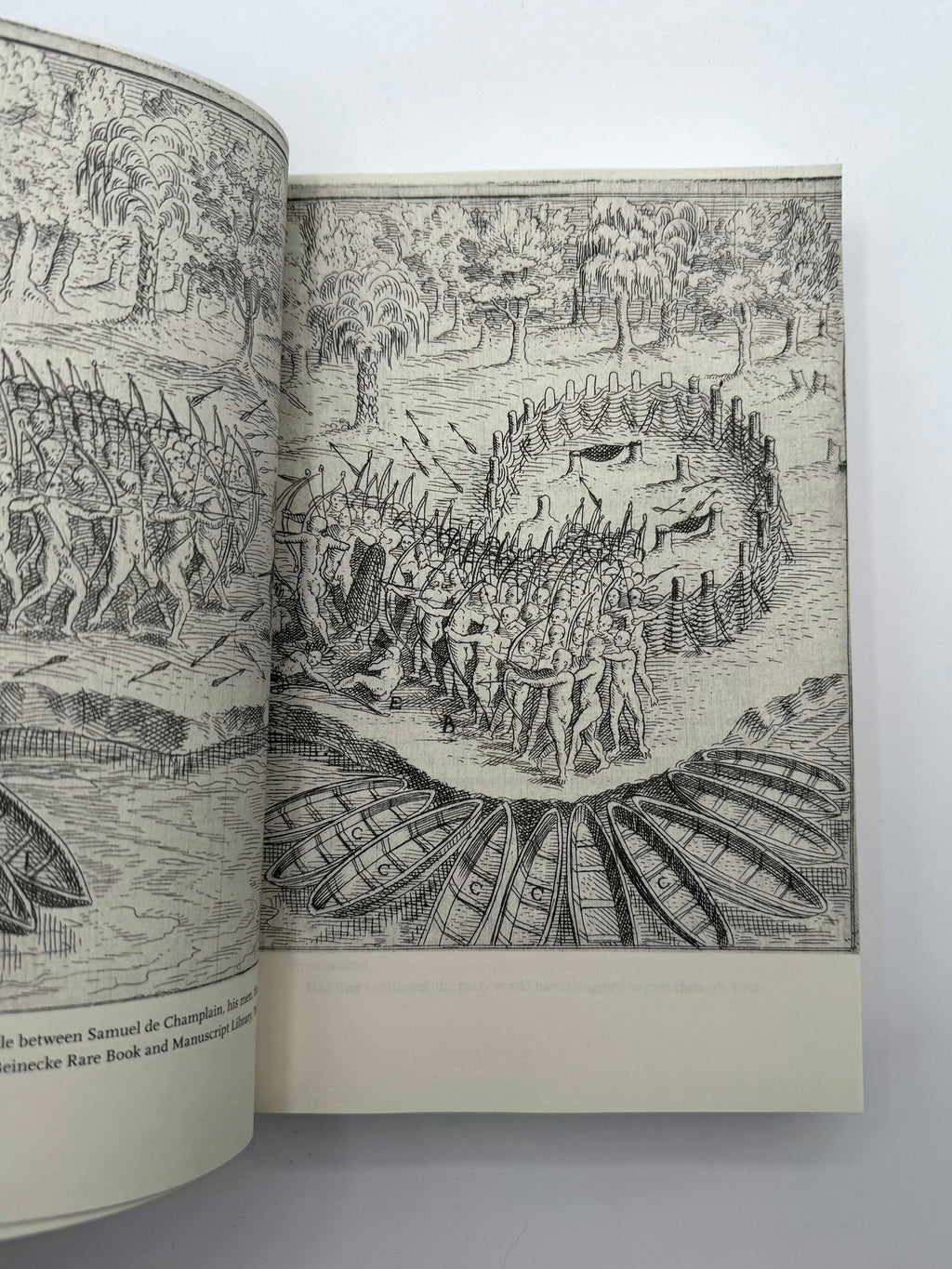 Open book displaying detailed black and white illustrations of a historical battle scene.