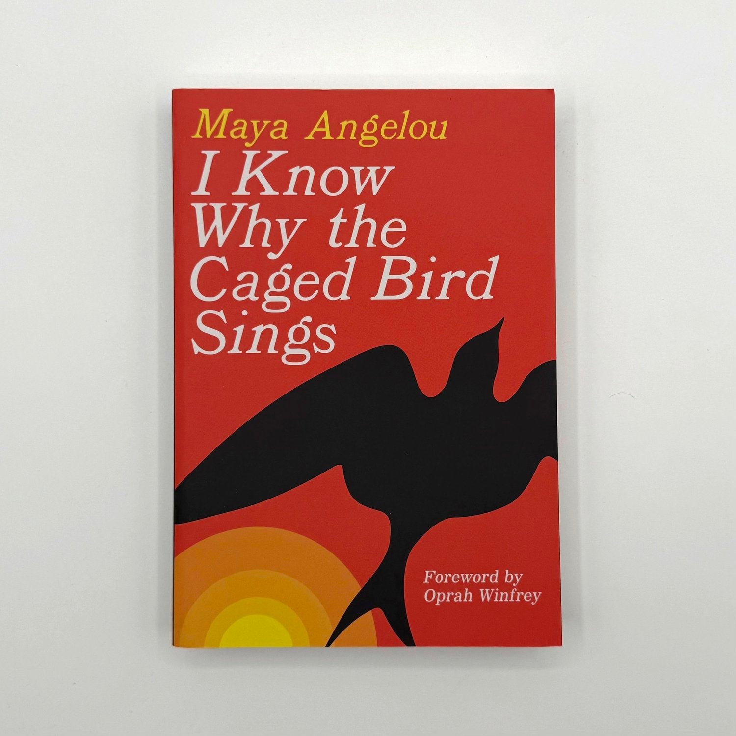 Book cover of 'I Know Why the Caged Bird Sings' by Maya Angelou with a silhouette of a bird on a red background.