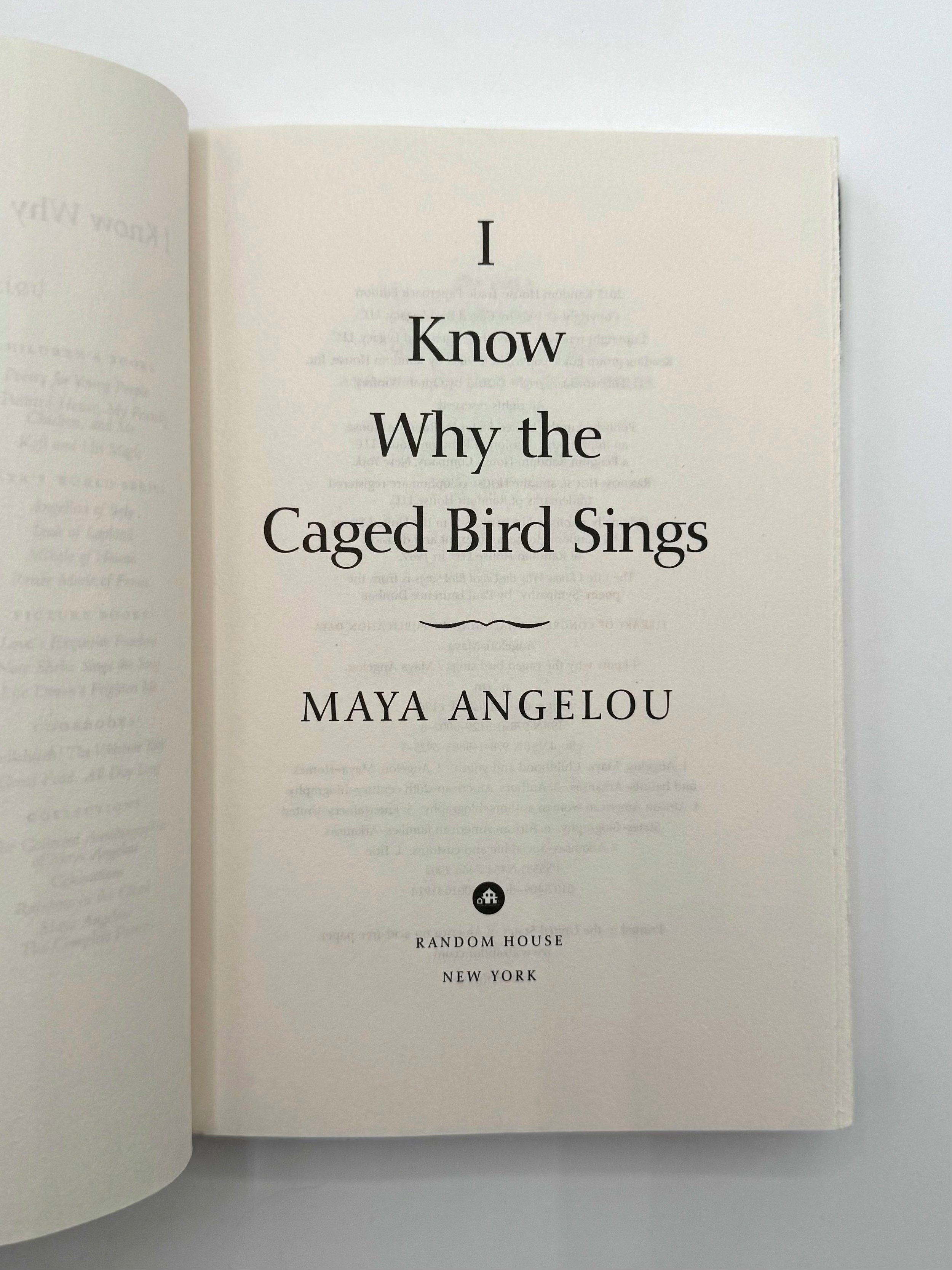 Open book with 'I Know Why the Caged Bird Sings' by Maya Angelou on a white background