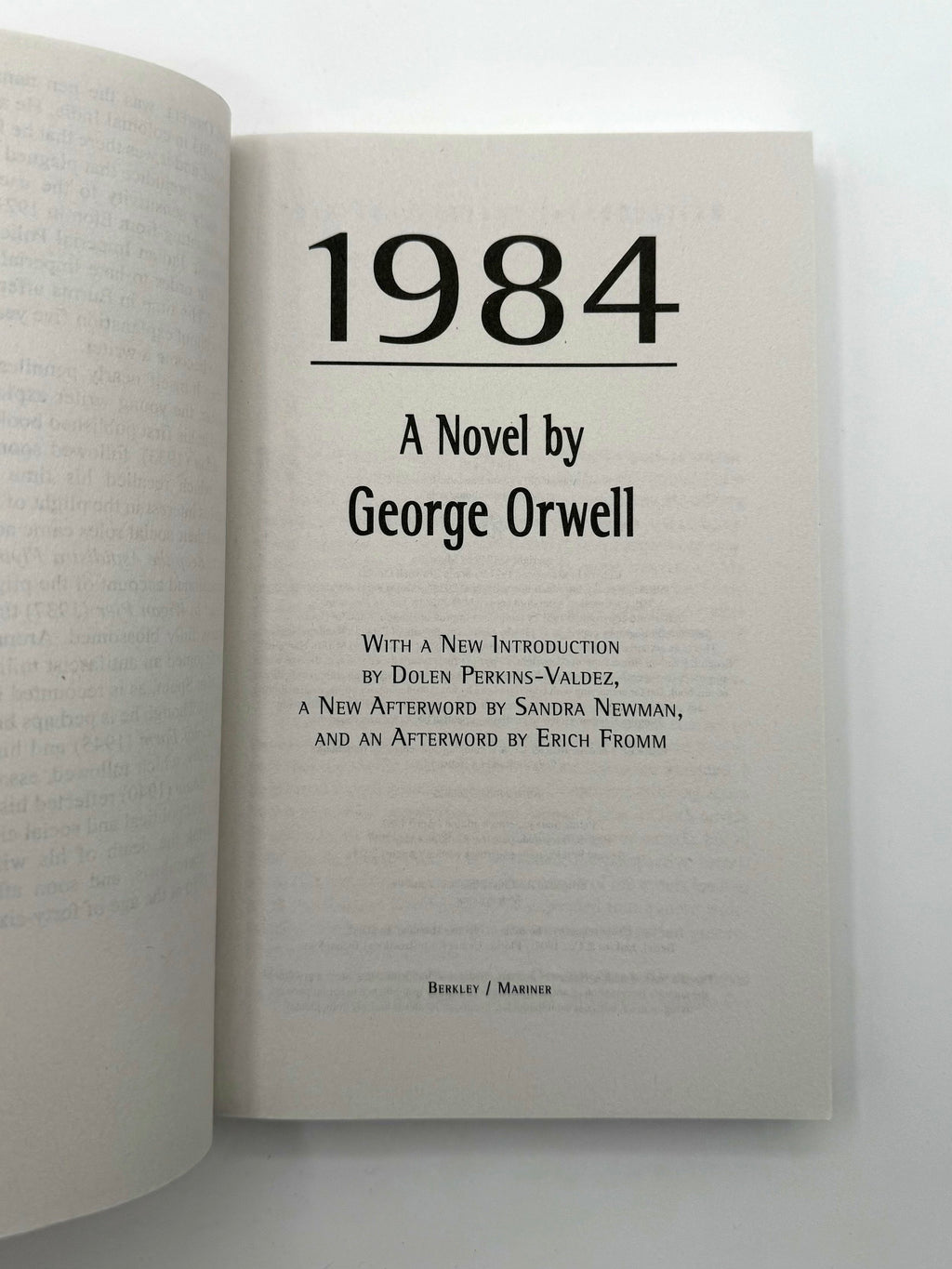 Open book displaying the title '1984' by George Orwell on a white background