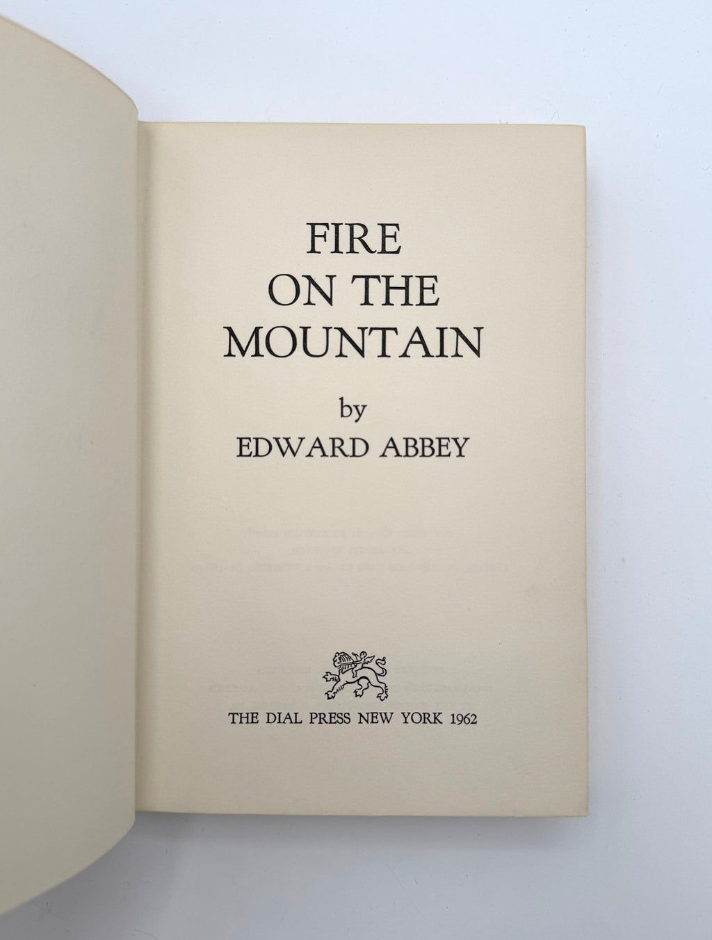 Book titled 'Fire on the Mountain' by Edward Abbey with a visible logo on a light background