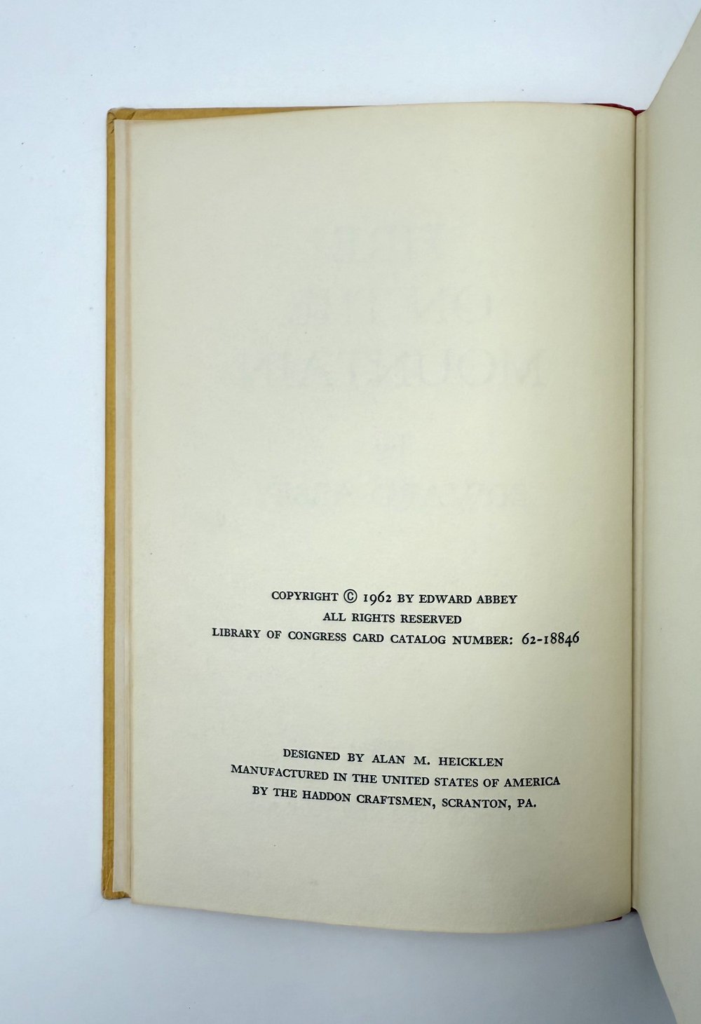 Open book with copyright and design information on a light gray background