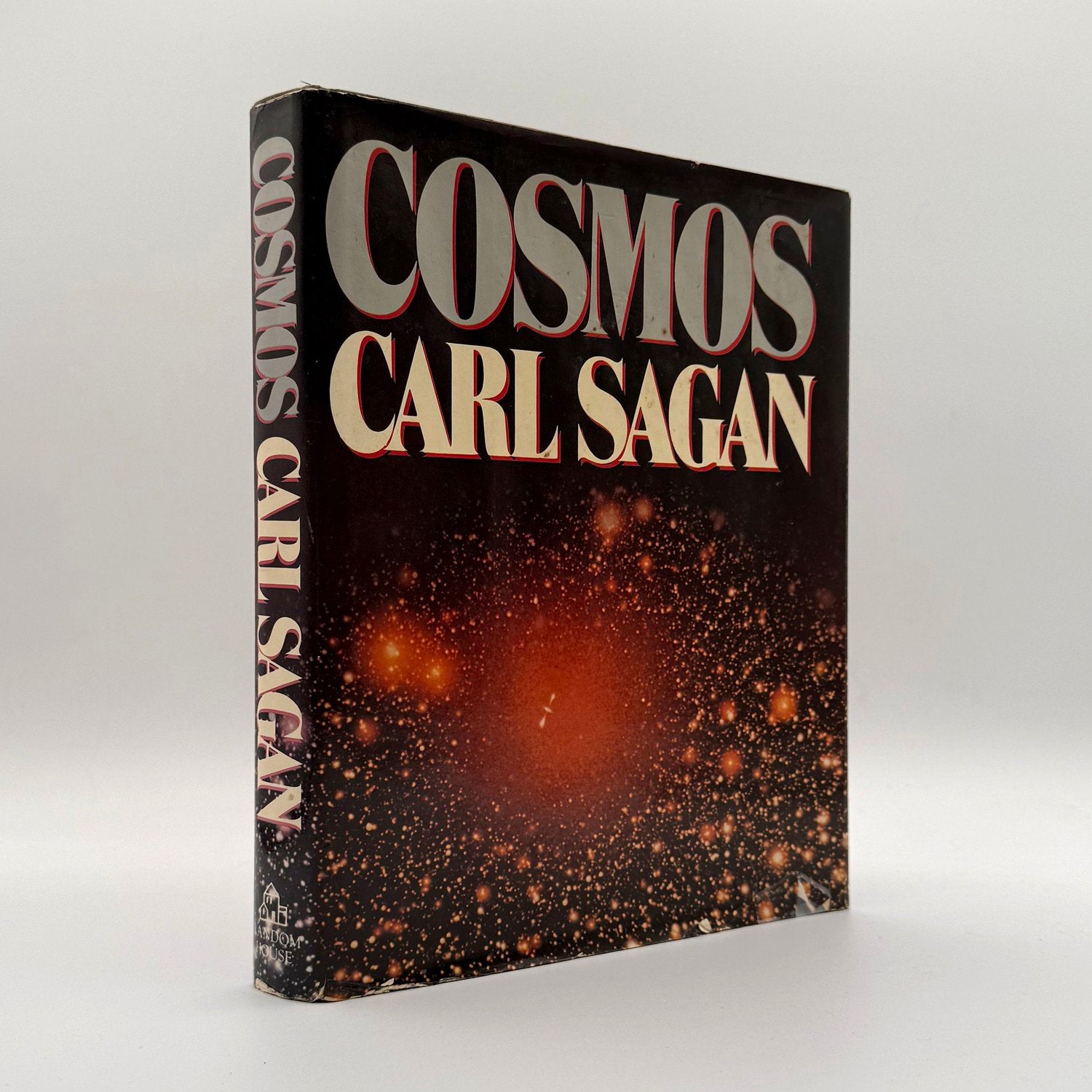Book titled 'Cosmos' by Carl Sagan with a space-themed cover on a white background