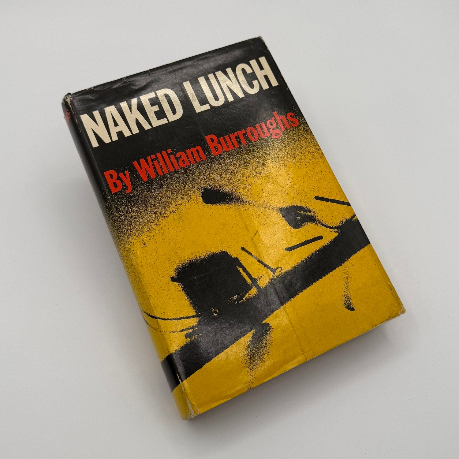 Book titled 'Naked Lunch' by William Burroughs on a gray background
