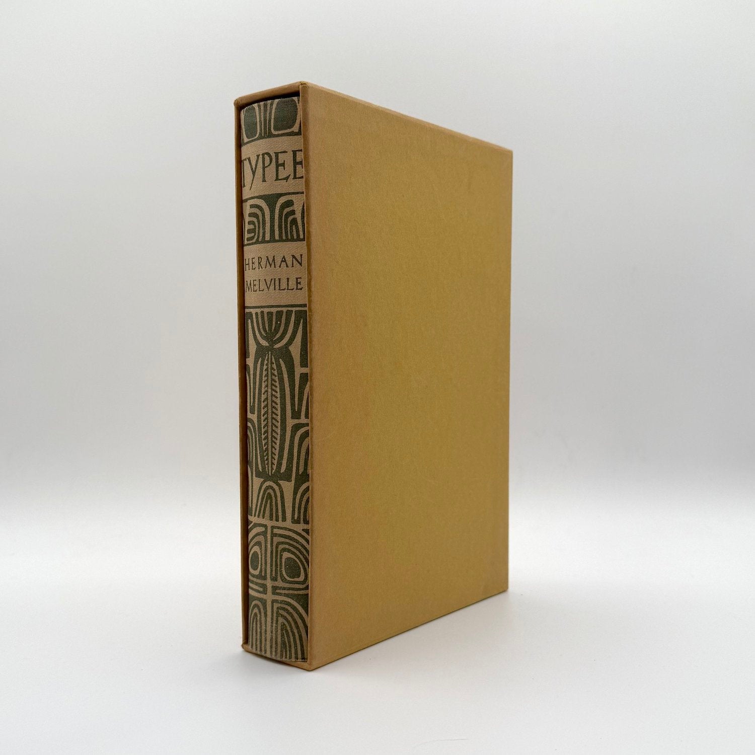 Brown slipcase with book with embossed design on spine on a white background
