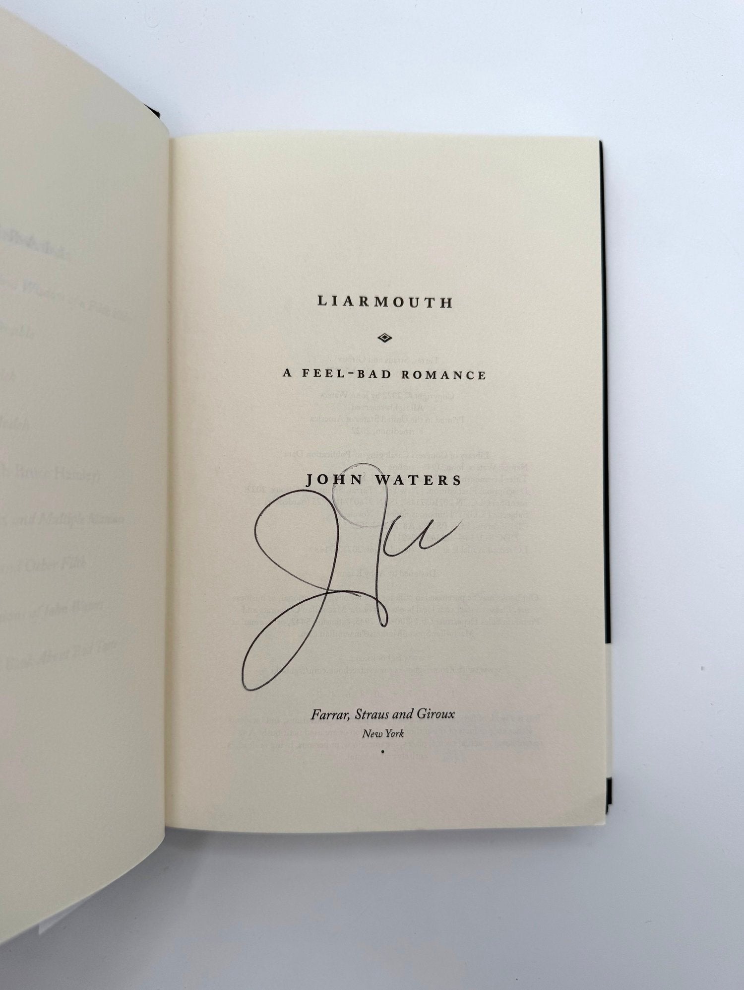 Open book "Liarmouth" by John Waters, Signed on a white background