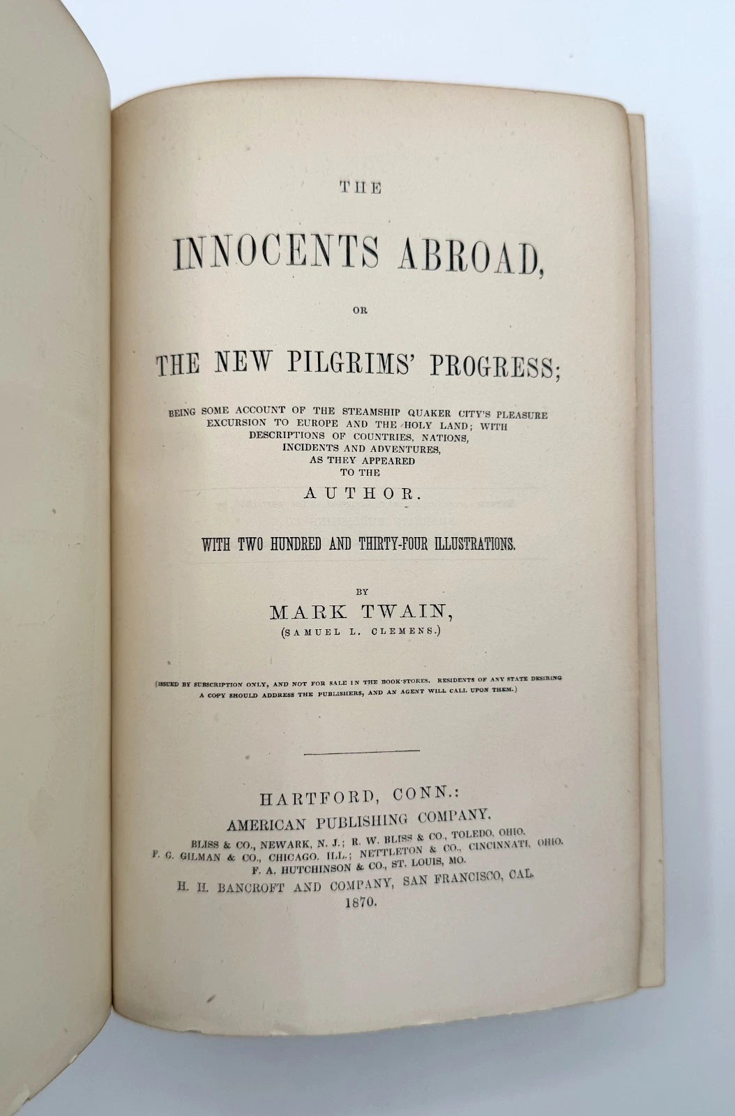 Open book showing the title page of 'The Innocents Abroad' by Mark Twain on a white background.