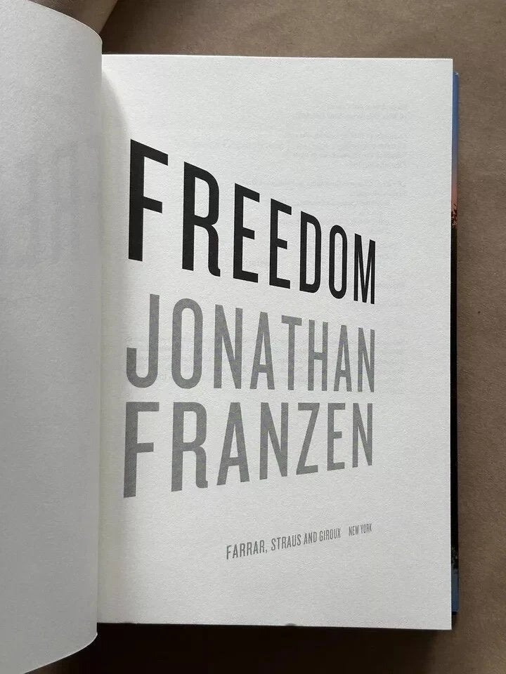Open book with 'Freedom' by Jonathan Franzen on a brown background