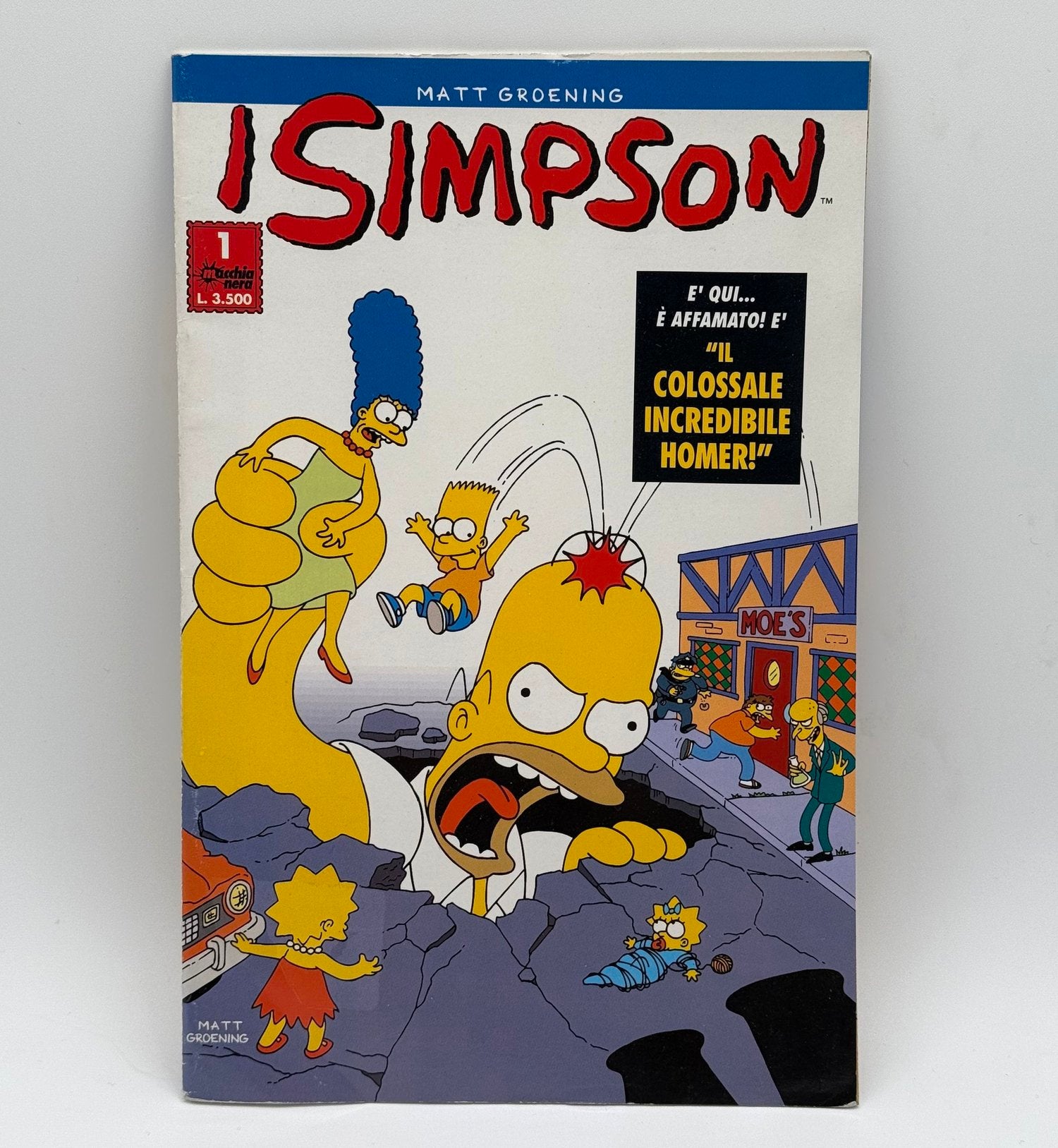 Comic book cover featuring The Simpsons family with a blue border and text.
