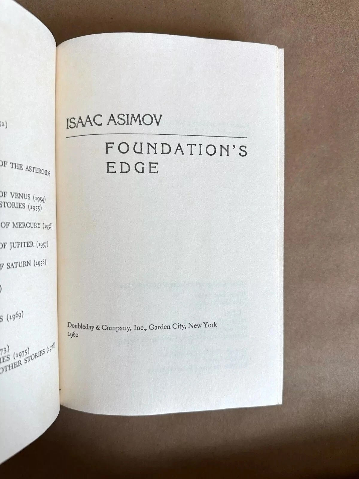 Open book showing Isaac Asimov's 'Foundation's Edge' on a brown background