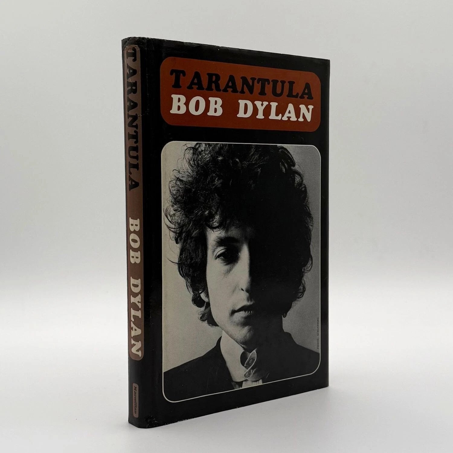 Book cover of 'Tarantula' by Bob Dylan with a black and white portrait on a white background