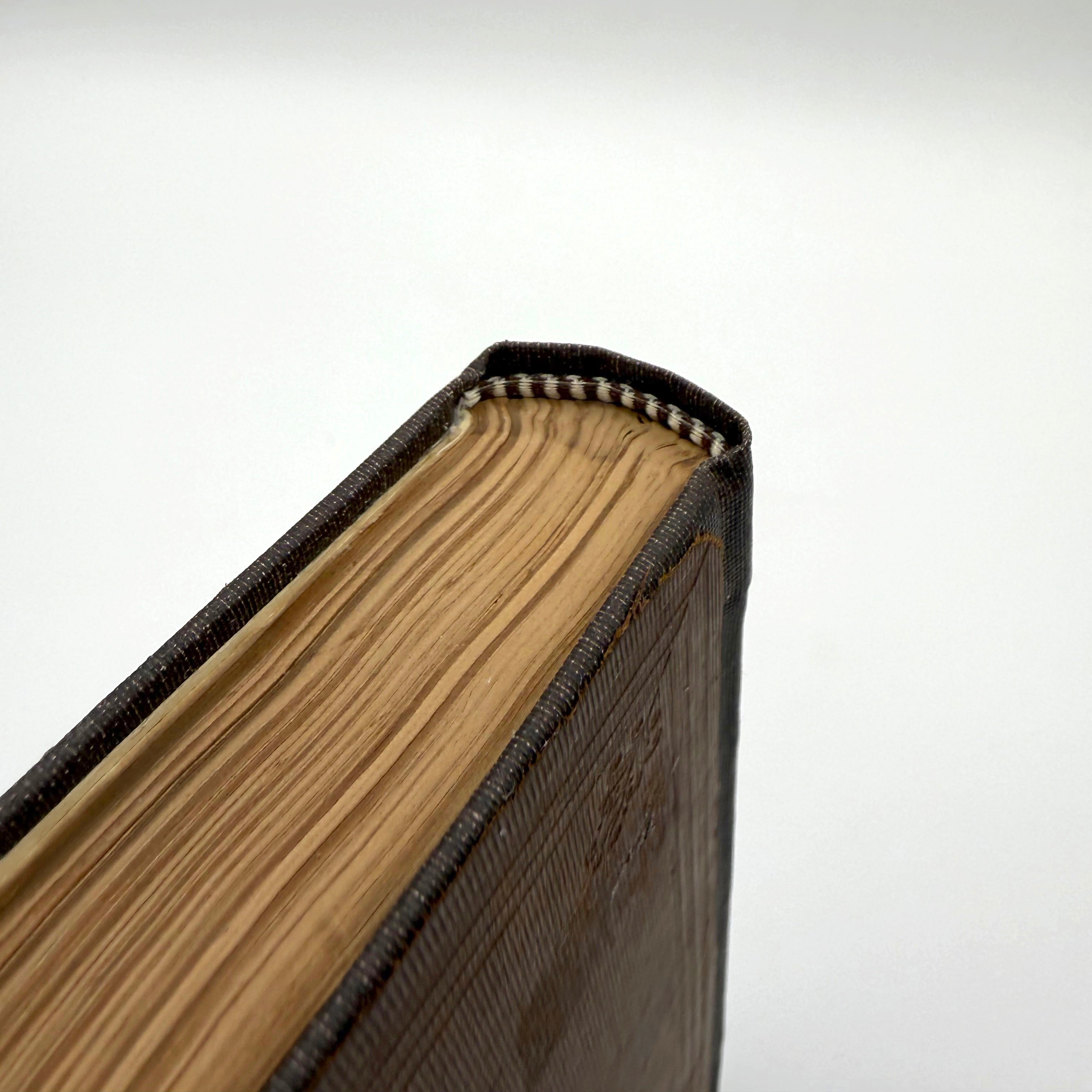 Close-up of a book with visible headband stitching on a white background