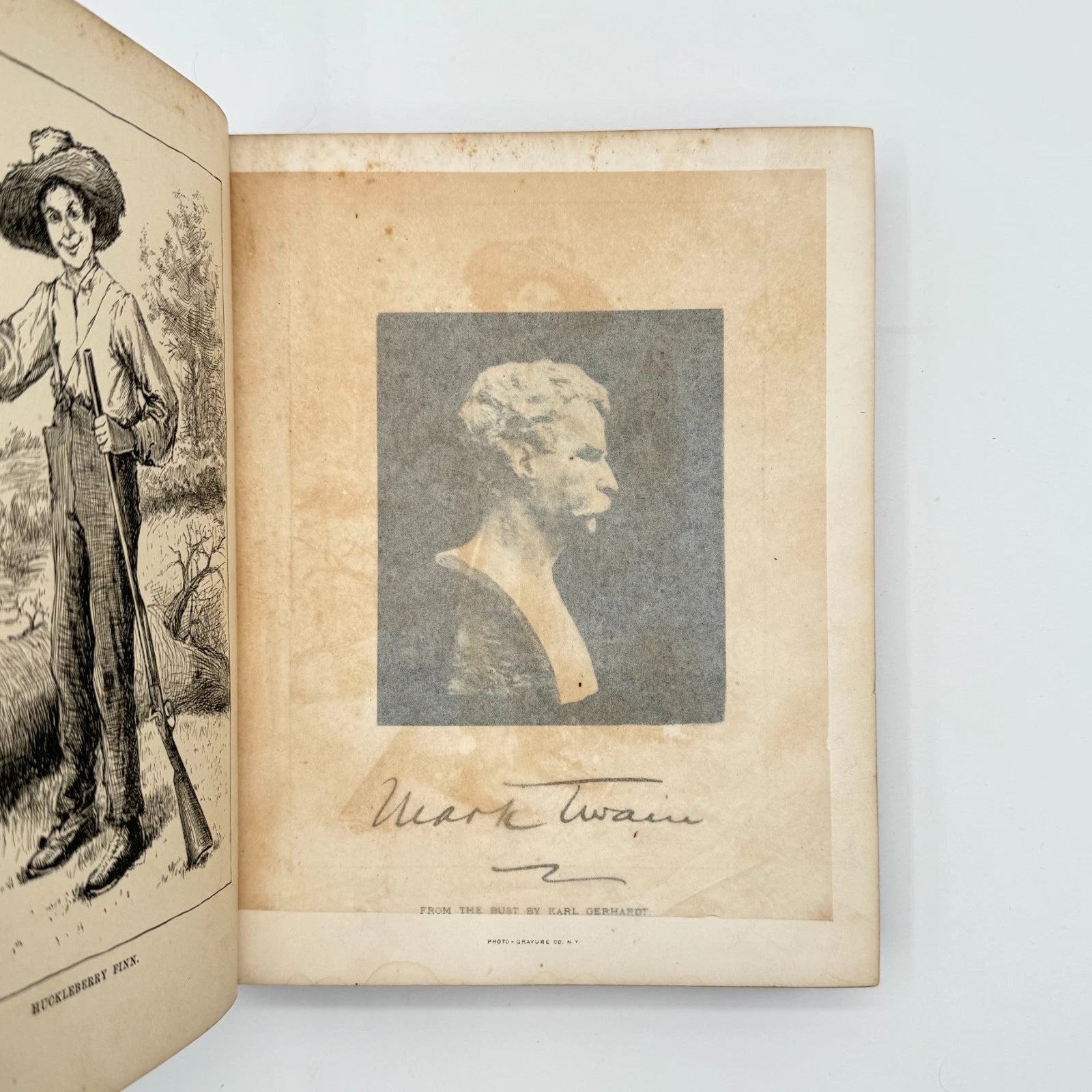 Open book with illustrations and a portrait of Mark Twain on a white background