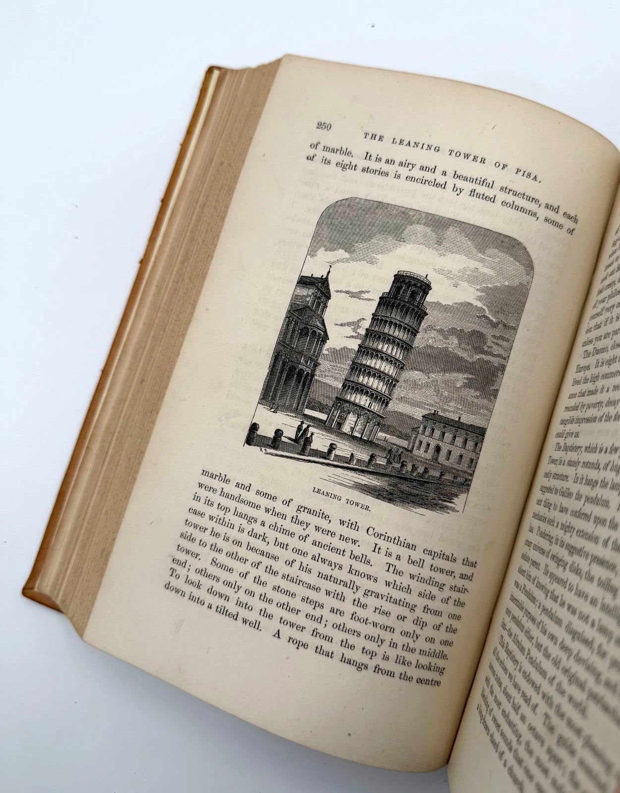 Open book with illustration of the Leaning Tower of Pisa on a white background